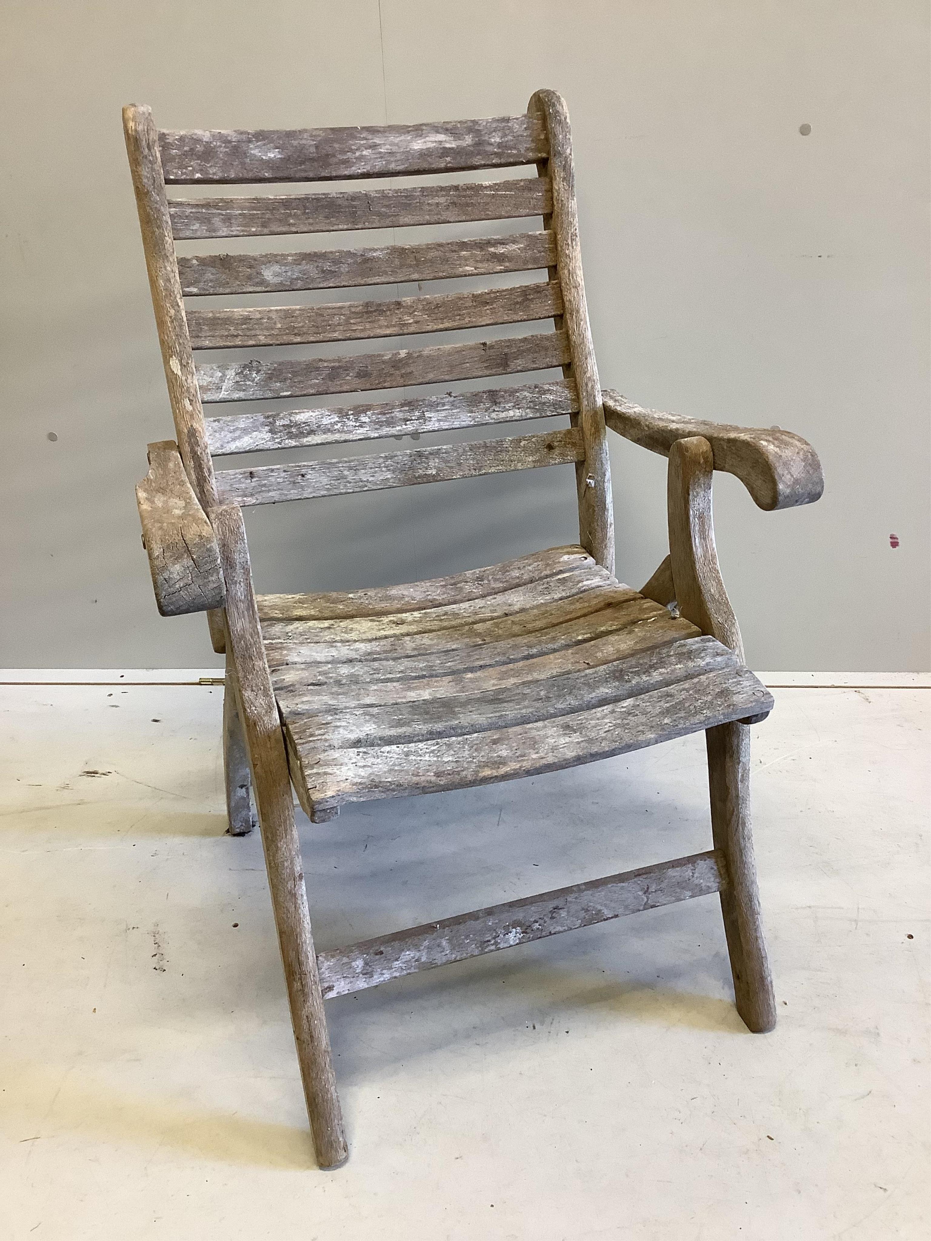 An Alexander Rose circular teak folding garden table with a set of four folding chairs. Condition - table fair, chairs more notably weathered